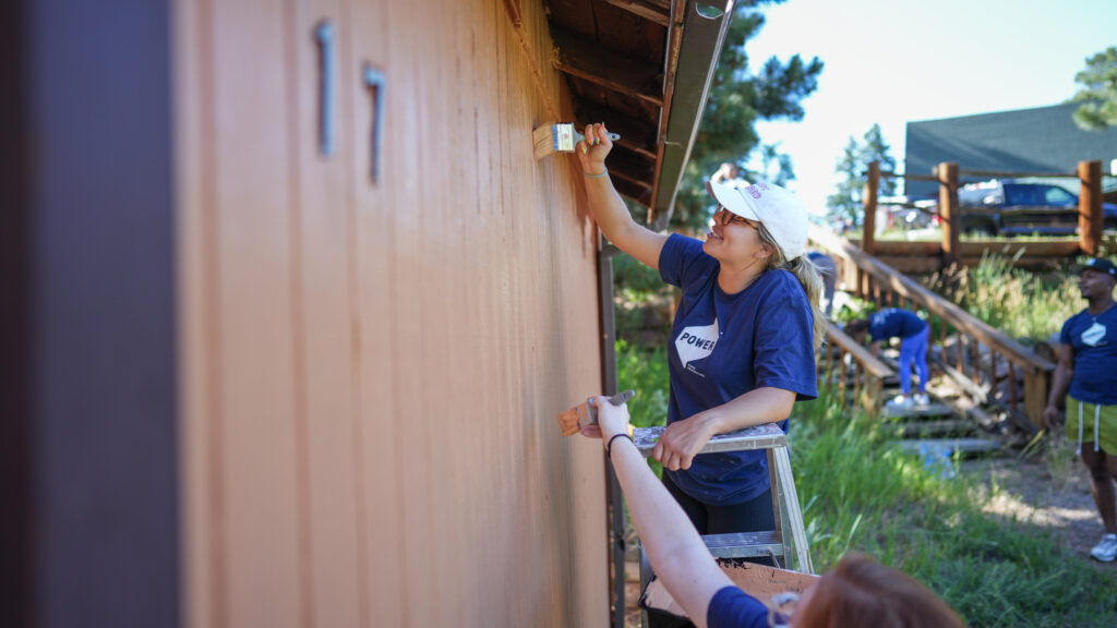 employee painting house during volunteer project