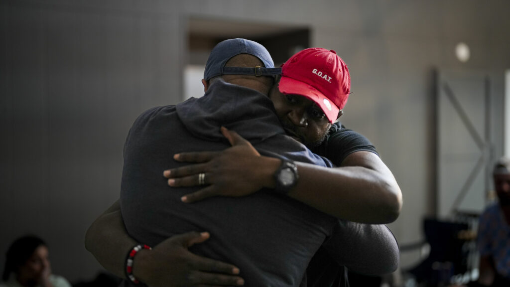 Two POWER employees embrace one another and provide a comforting hug during a group talk session at POWER's Veteran Expedition. 