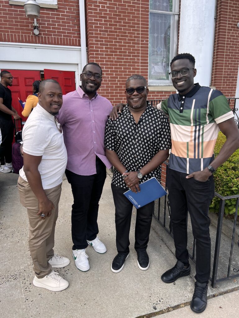 Four employees pose for a photo outside the Calvary Baptist Church in Chester, PA during POWER's Juneteenth event.