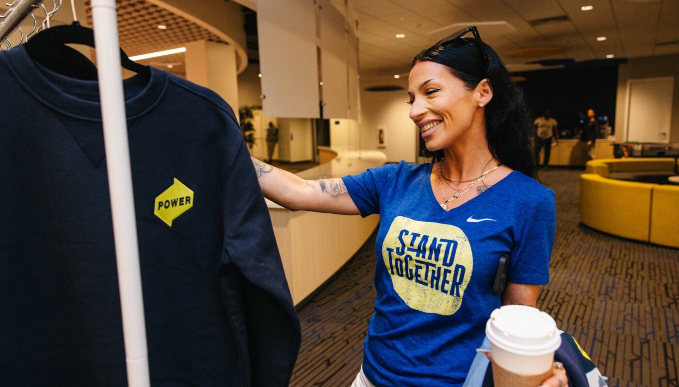 Power employee peruses through a rack of Alex's and POWER branded merchandise.