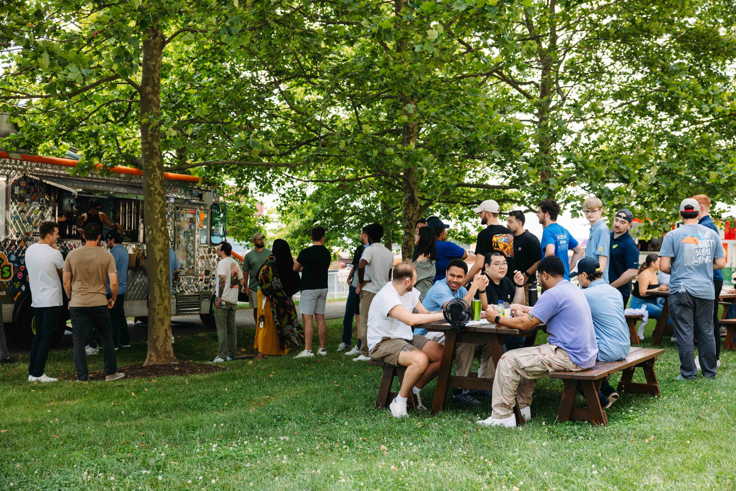 Power employees sit at picnic tables and grad lunch at food trunks during waterfront wednesday event to raise awareness for Summer of Alex's initiative.