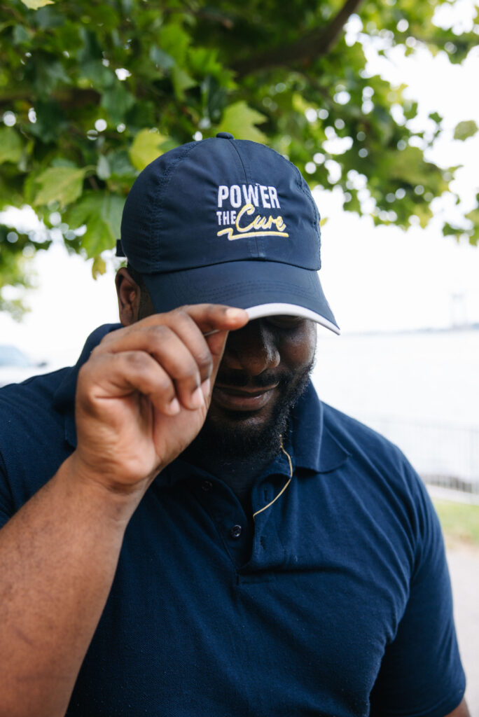 A POWER employee shows off a hat stitched with the words, "power the cure."