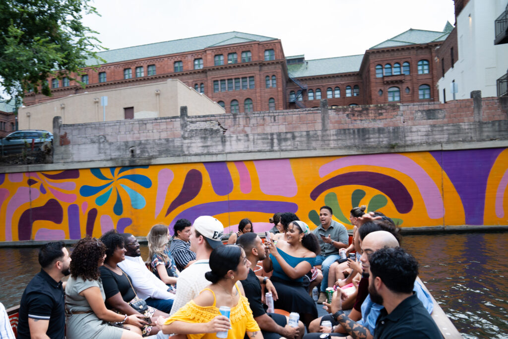 Mi Gente event attendees take an evening boat tour to see the sites of vibrant San Antonio. 