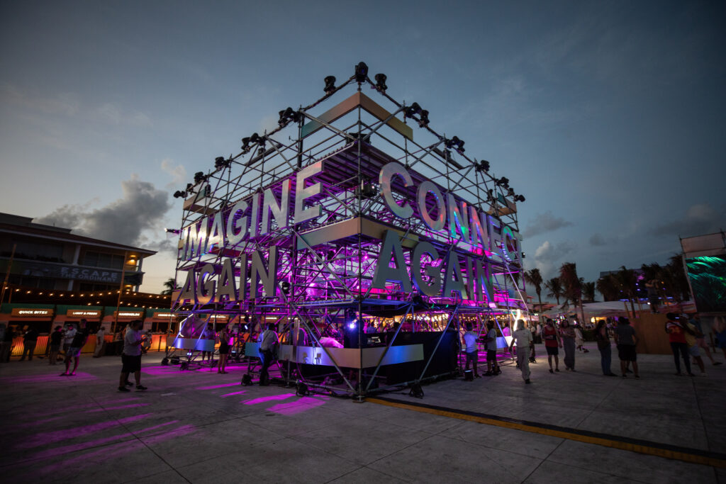 A massive industrial installation is displayed at a past Quest event with the words " imagine again" and "dream again."