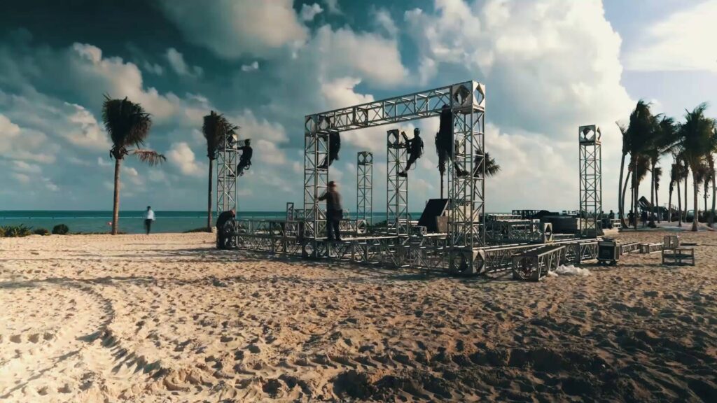 Workers begin building the Quest stage on the beach in Cancun.