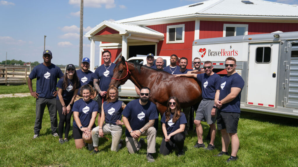 POWER Veteran employees pose for a group photo at the BraveHearts farm.