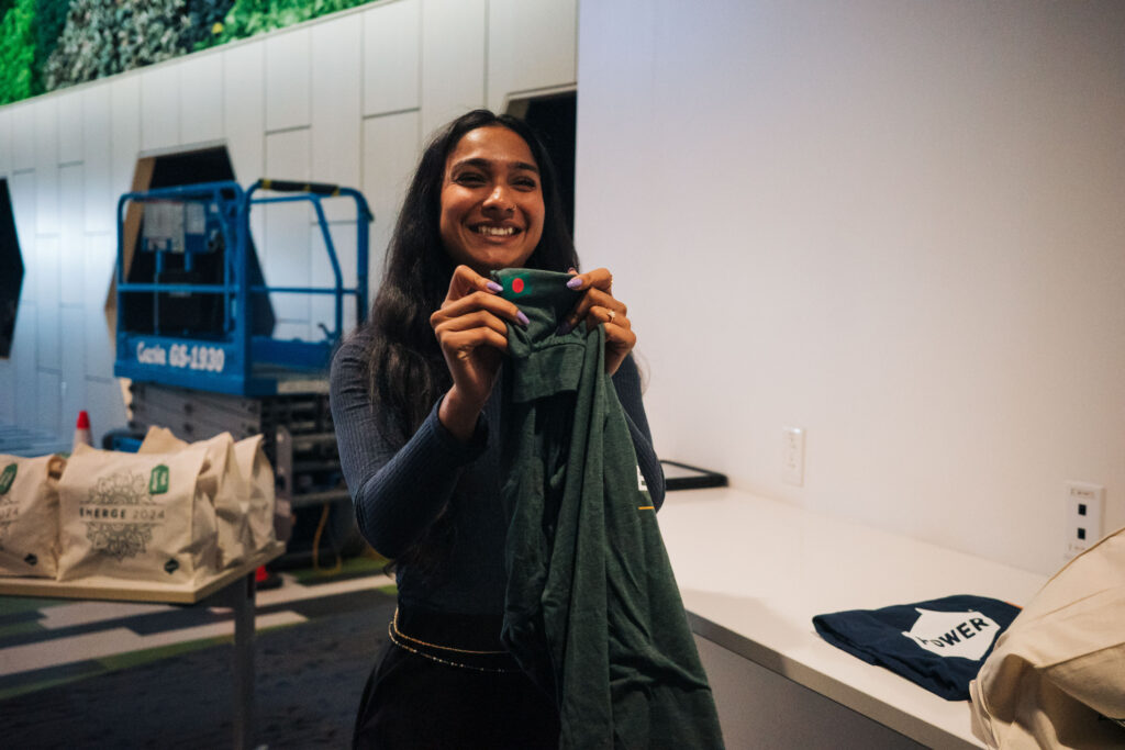 An Emerge attendee holds up a t-shirt with a patch of the flag of her native country.