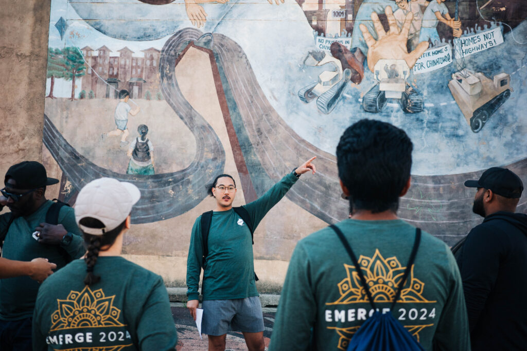 Power employee points at a mural during a walking tour of Chinatown in Philadelphia. 